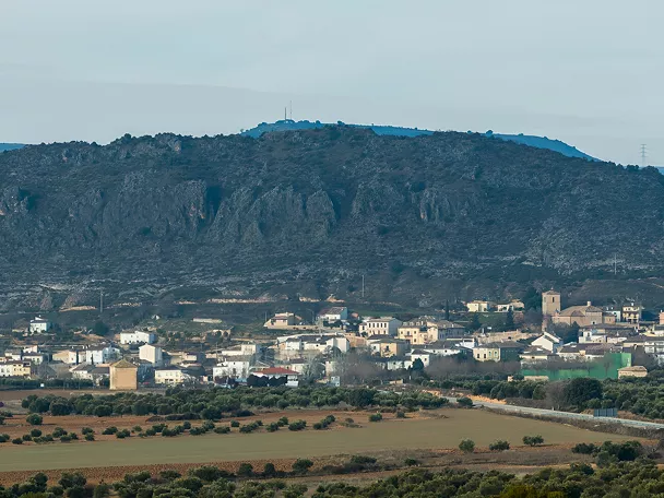 Vista panorámica de un pueblo rodeado de campos y sierras.