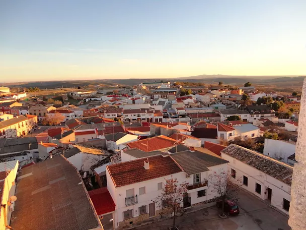 Vista panorámica de un pueblo medieval con casas blancas y tejados de teja.