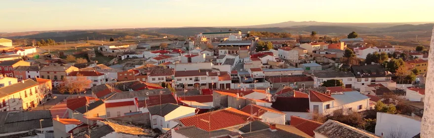 Vista panorámica de un pueblo medieval con casas blancas y tejados de teja.