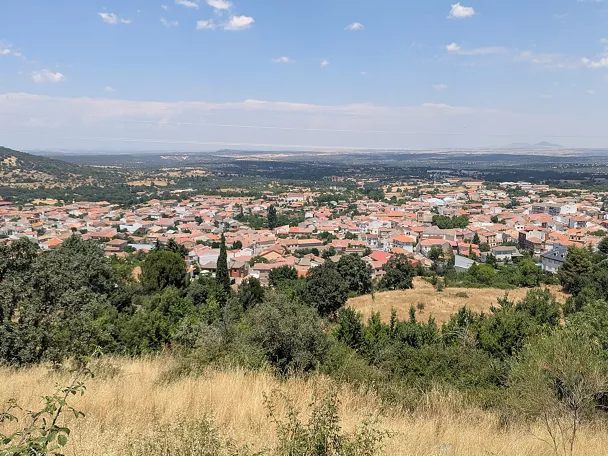 Vista panorámica de un pueblo rodeado de colinas y campos.