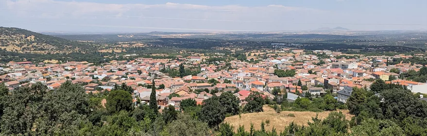 Vista panorámica de un pueblo rodeado de colinas y campos.
