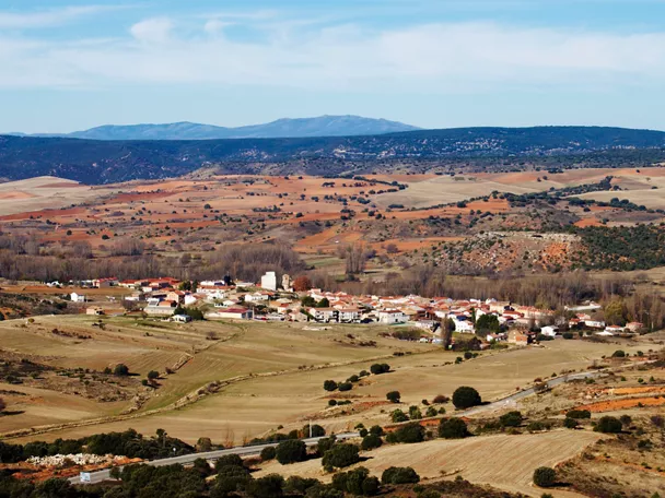 Vista panorámica de un pueblo rodeado de campos y colinas.