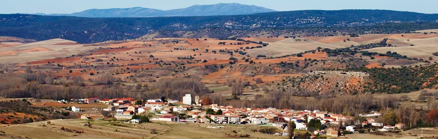 Vista panorámica de un pueblo rodeado de campos y colinas.