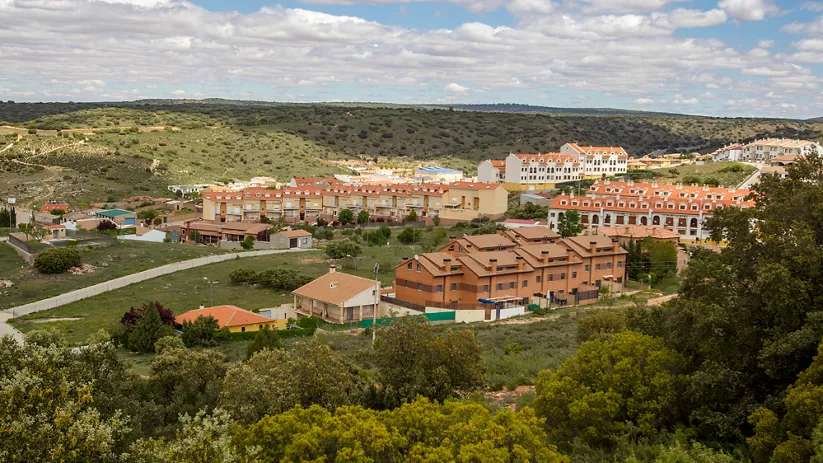 Vista panorámica de un núcleo urbano entre lomas y zonas verdes.