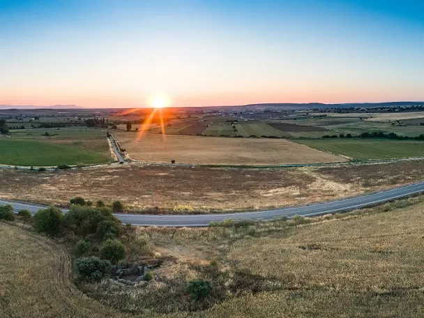 Paisaje agrícola al atardecer con campos y carretera