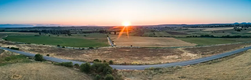 Paisaje agrícola al atardecer con campos y carretera