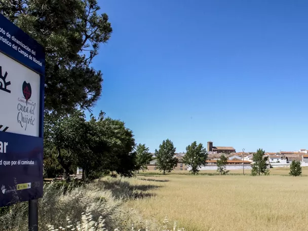 Entrada a Cózar con campos y pueblo al fondo.