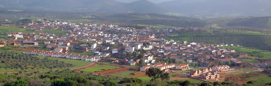 Vista panorámica de un pueblo rodeado de campos y colinas
