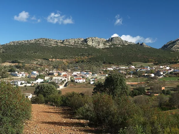 Vista panorámica del pueblo con casas blancas y sierra rocosa al fondo