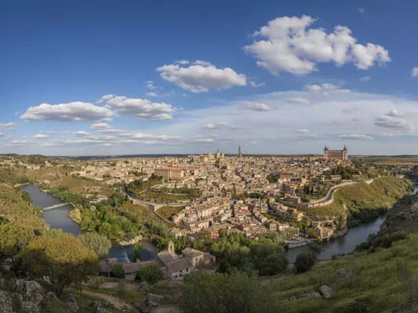Panorámica urbana rodeada por un río y colinas verdes