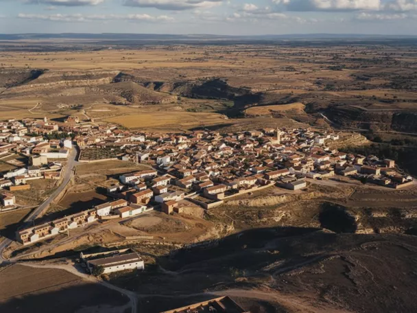 Vista aérea de un pueblo rodeado de campos y colinas