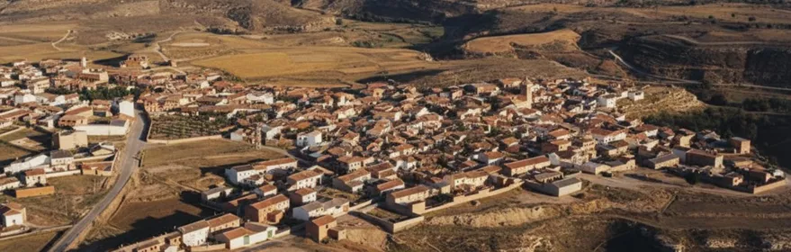Vista aérea de un pueblo rodeado de campos y colinas