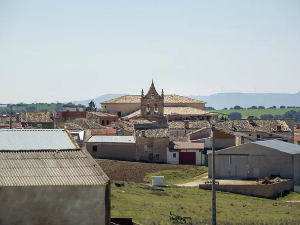 Vista general de un pueblo con tejados y una iglesia al fondo.