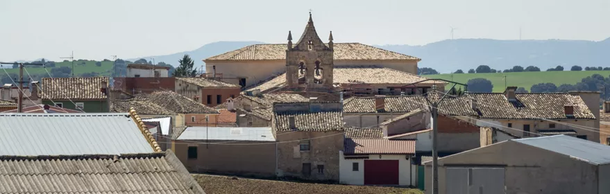 Vista general de un pueblo con tejados y una iglesia al fondo.