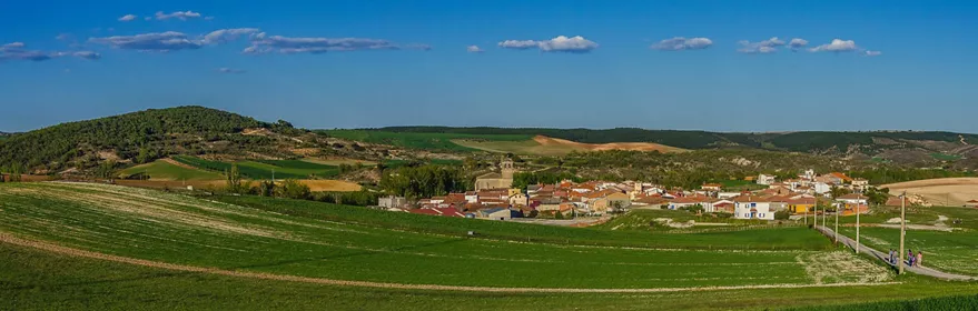 Vista panorámica de un pueblo rodeado de colinas y campos.