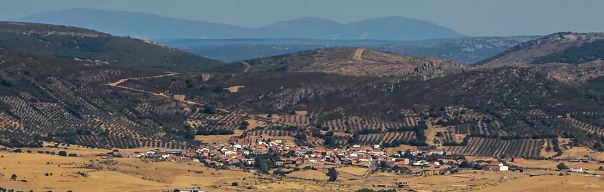 Vista panorámica del caserío rodeado de dehesa y colinas suaves