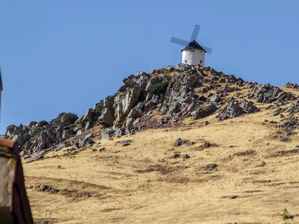 Molino de viento blanco sobre un cerro rocoso y seco