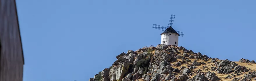Molino de viento blanco sobre un cerro rocoso y seco
