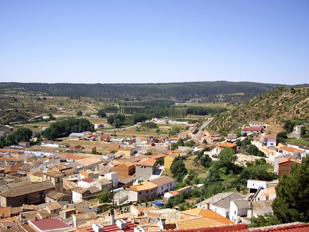 Vista general de un pueblo entre colinas verdes.