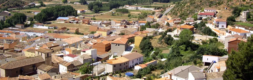 Vista general de un pueblo entre colinas verdes.