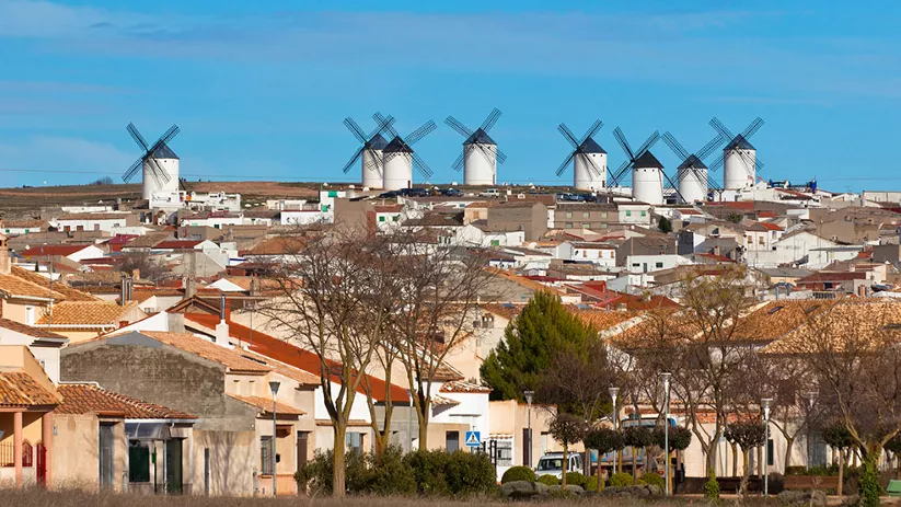 Panorámica urbana con molinos de viento en la colina