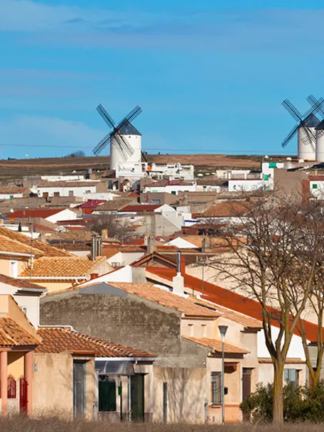 Panorámica urbana con molinos de viento en la colina