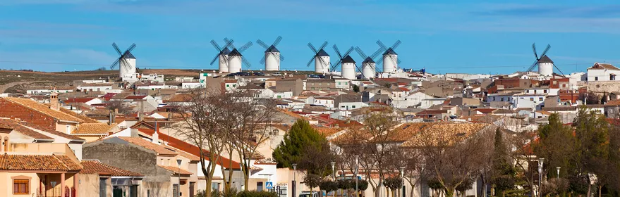 Panorámica urbana con molinos de viento en la colina