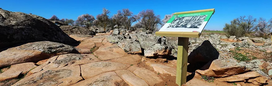 Sendero rocoso con panel interpretativo al aire libre