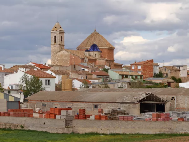 Vista panorámica de pueblo con iglesia, naves industriales y campos