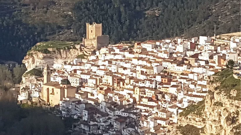 Vista aérea de pueblo compacto sobre un desfiladero rocoso.
