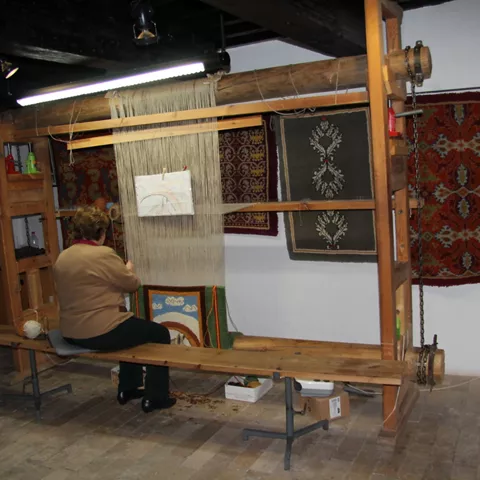 Imagen de una persona haciendo una alfombra de nudo