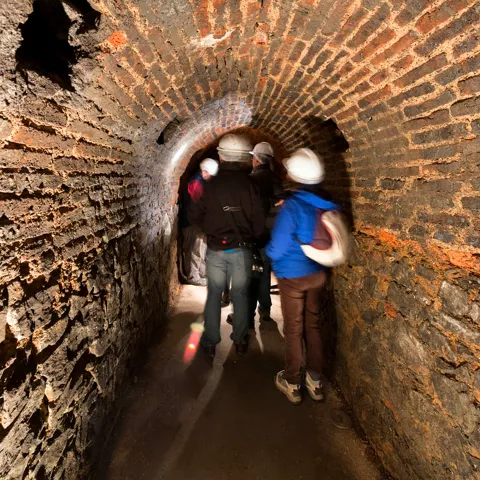 Visitantes en una galería de ladrillo de la Mina de Almadén