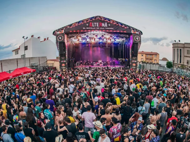 Público reunido frente a un gran escenario durante un festival.