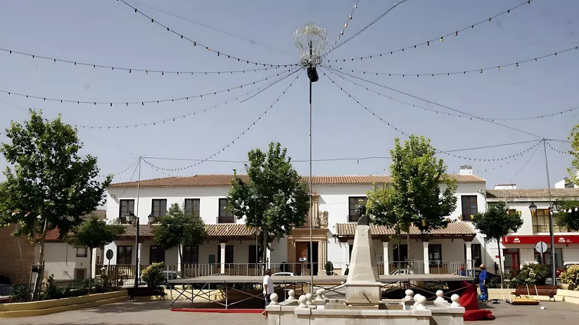 Plaza con fuente central, árboles y luces decorativas