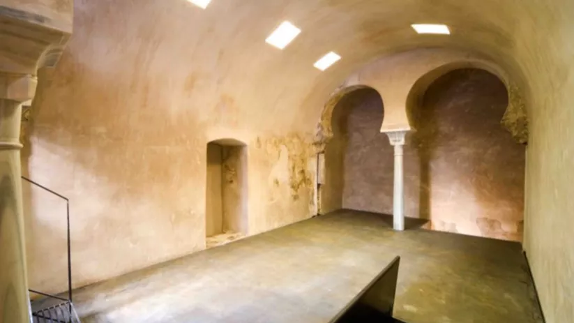Sala abovedada con lucernarios en el techo y arcos de herradura sostenidos por una columna central.
