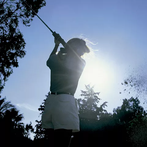 Imagen de una mujer golpeando la pelota de golf