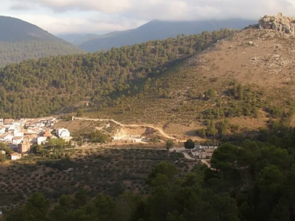 Vista panorámica de pueblo blanco entre montañas y pinares