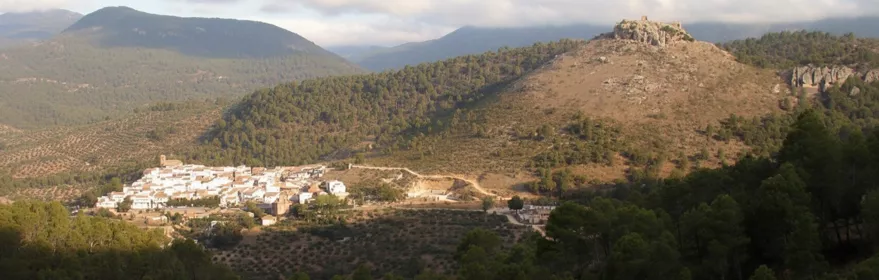 Vista panorámica de pueblo blanco entre montañas y pinares