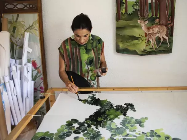 Imagen de mujer decorando una tela