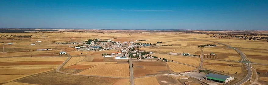Vista aérea de pueblo rodeado de campos y carreteras