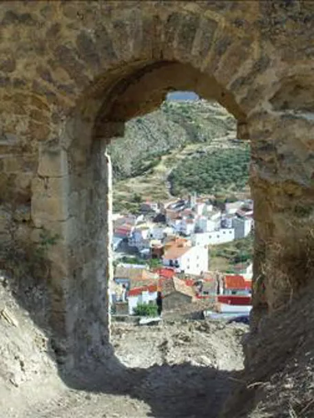 Imagen del pueblo de Enguídanos a través de un arco de piedra