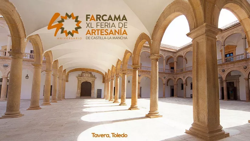 Patio renacentista con arcos de piedra y logotipo de feria