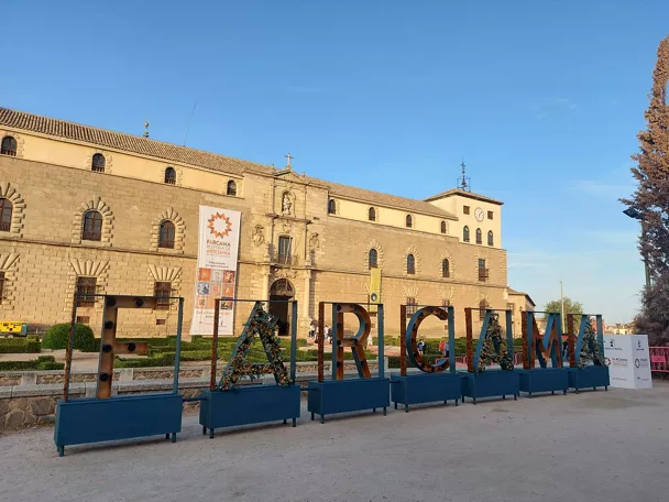 Fachada histórica con letras decorativas de feria delante