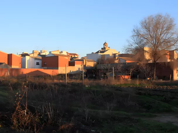 Vista del pueblo al atardecer con campanario al fondo