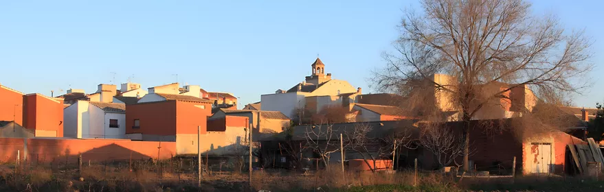 Vista del pueblo al atardecer con campanario al fondo