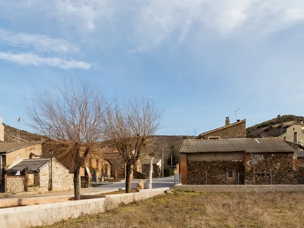 Vista de pueblo rural con casas de piedra y colinas alrededor