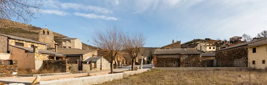 Vista de pueblo rural con casas de piedra y colinas alrededor