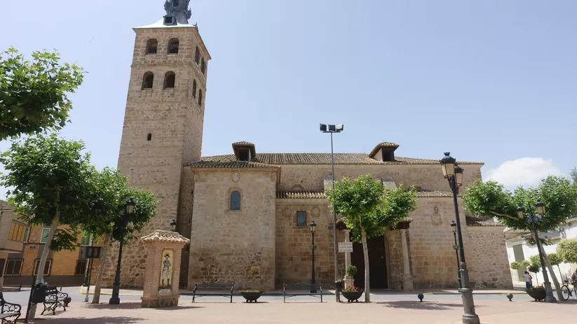 Iglesia de piedra con torre alta y jardín frontal