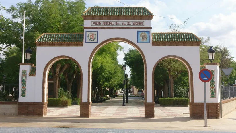 Entrada con tres arcos a un parque arbolado
