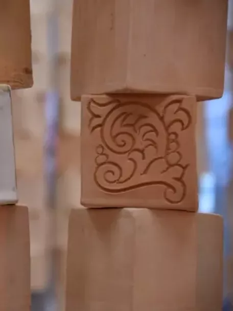 Imagen de piezas de barro con un escarabajo y otro dibujo